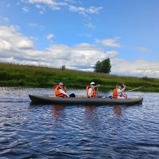 Путешествие на каяке по спокойной реке в ясный солнечный день с друзьями