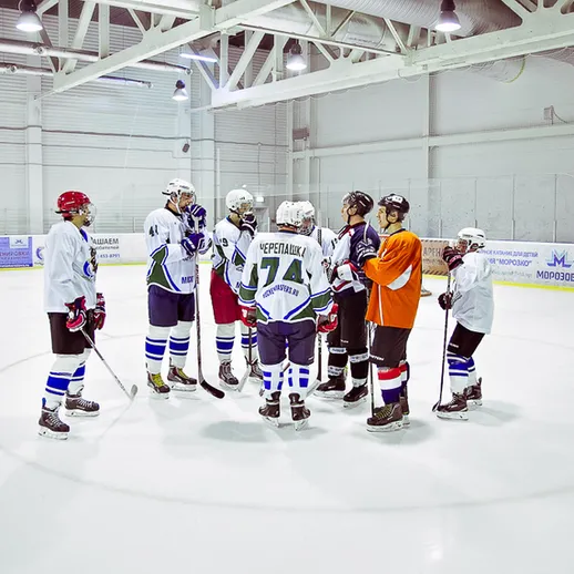 Тренировка хоккейной команды в закрытом льдовом комплексе в вечернее время