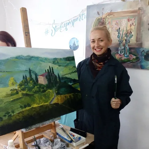 Молодая художница показывает свою картину в мастерской, окруженной красивыми пейзажами в стиле импрессионизма