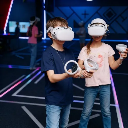 Дети играют в виртуальной реальности в игровом центре, используя очки и контроллеры