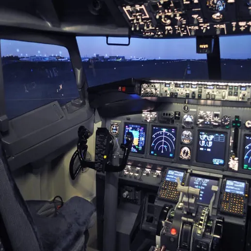 Кабина управления самолета с современными приборами и освещением в вечернее время