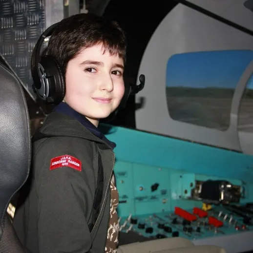 Молодой парень в кабине самолета, погруженный в процесс обучения пилотированию в авиационном центре
