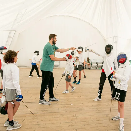 Занятия фехтованием для детей на открытом воздухе в спортивном лагере у воды
