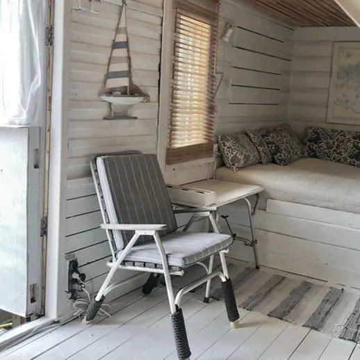 Уютный уголок на берегу воды с кроватью и креслом, идеальное место для отдыха и чтения