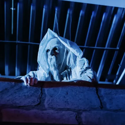 Страшный призрак наблюдает за людьми в заброшенном здании ночью