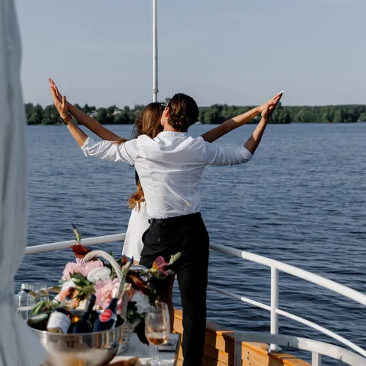 Два человека наслаждаются моментом на борту яхты в солнечный день на водоёме