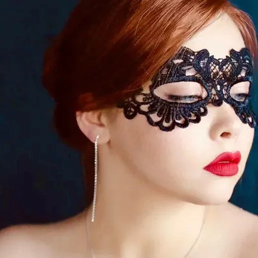 Утонченная женщина в маске на фоне темно-синего цвета во время вечеринки