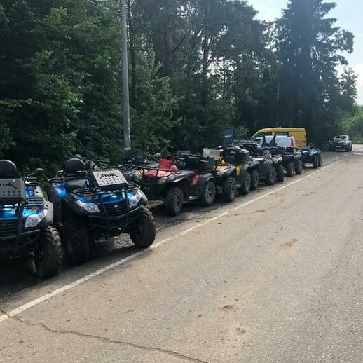 Многочисленные квадроциклы стоят вдоль дороги в загородной местности под солнечным небом