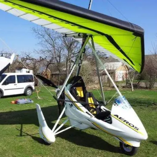 Легкий самолет с крылами ярко-зеленого цвета на травяном поле весной, готовый к взлету