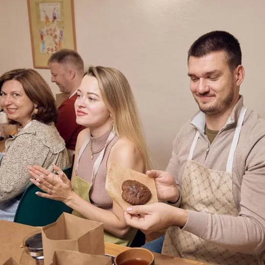 Участники мастер-класса по выпечке в уютном кафе, наслаждаясь процессом создания десертов и общением, осень 2023 года