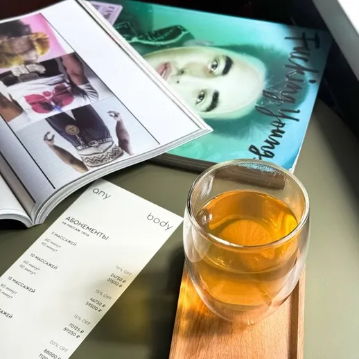 Чай в стеклянном стакане на столе рядом с журналом и меню в уютном кафе