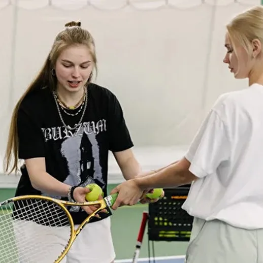Теннисные тренировки в закрытом зале с двумя спортсменками, обучающимися друг у друга