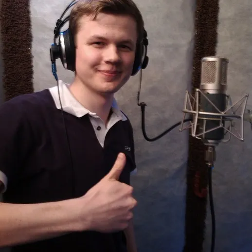 Молодой человек в студии звукозаписи работает с микрофоном и радуется результату в процессе записи