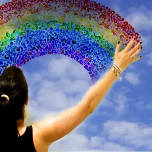 Женщина, тянущая руку к радуге на небе в ясный день