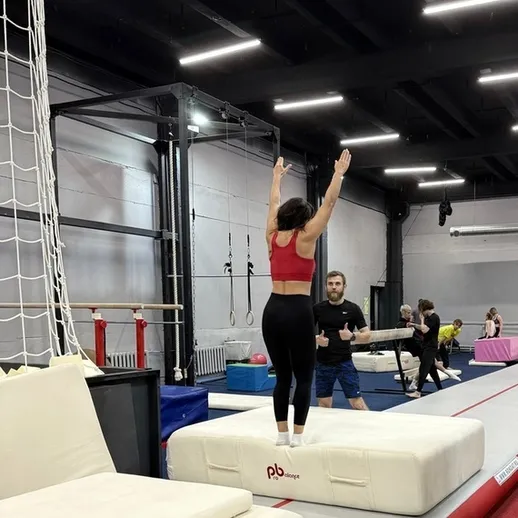 Тренировка гимнастов в зале с беговой дорожкой и матами