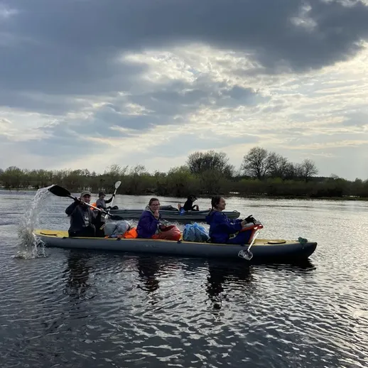 Групповая прогулка на каяках по реке под облачным небом