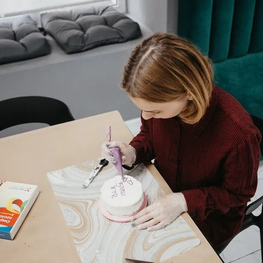 Женщина работает над декоративным элементом в дизайне интерьера на столе в светлом помещении