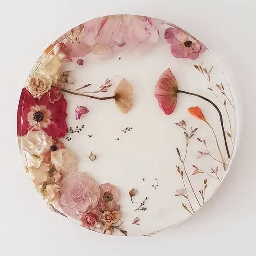 Образец декоративной тарелки с цветами из эпоксидной смолы в пастельных тонах на белом фоне