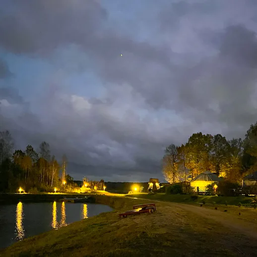 Ночной пейзаж у озера с уютными домиками и отражением в воде