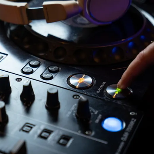 Диджей на сцене на вечеринке, управляет оборудованием и создает атмосферу музыки и радости в ночном клубе