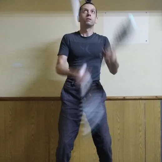 Мужчина жонглирует трюковыми предметами во время тренировки в тренажерном зале