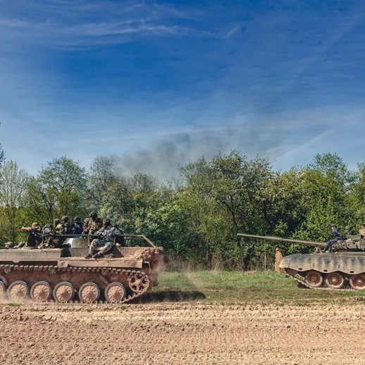 Военные учения танков в лесной местности на фоне ясного неба, весна 2023 года