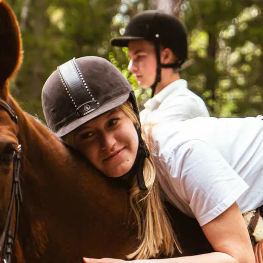 Девочка обнимает лошадь на конной ферме в лесу в летний день Девочка обнимает лошадь на конной ферме в лесу в летний день
