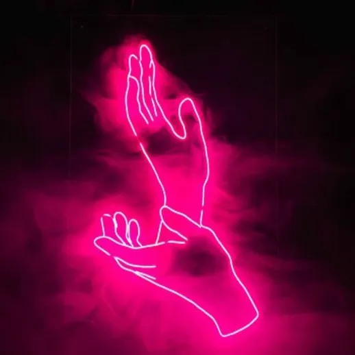Нежные руки в неоновом свете на фоне темного фона создают атмосферу уюта и волшебства в ночное время