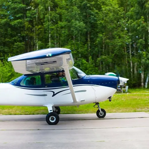Гражданский самолет на аэродроме в лесу рядом с небольшим поселком, лето, день