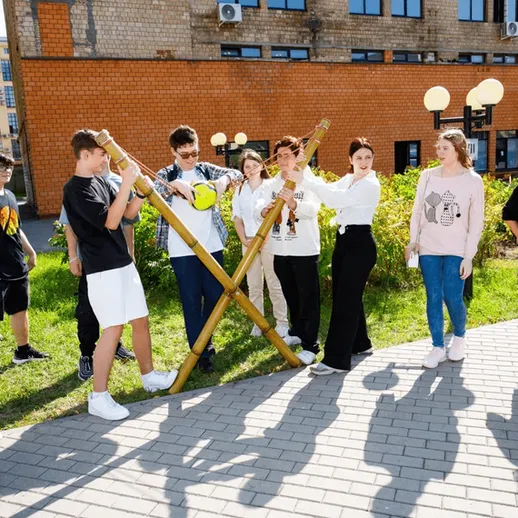 Группа молодых людей на улице проводит занятия по физической культуре в школьном дворе в солнечный день