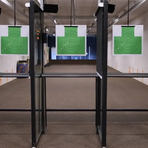 Стрельбище с мишенями на зелёном фоне в закрытом помещении для тренировок