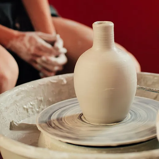 Изготовление глиняного горшка на гончарном круге в мастерской искусства