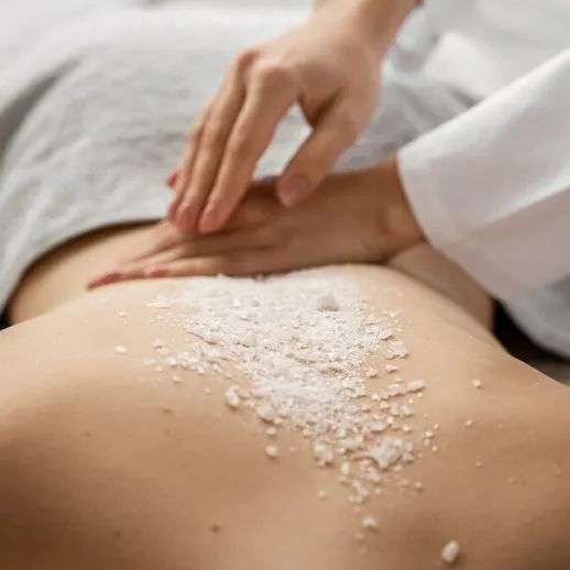 Массаж с использованием соли в спа-салоне во время процедуры расслабления