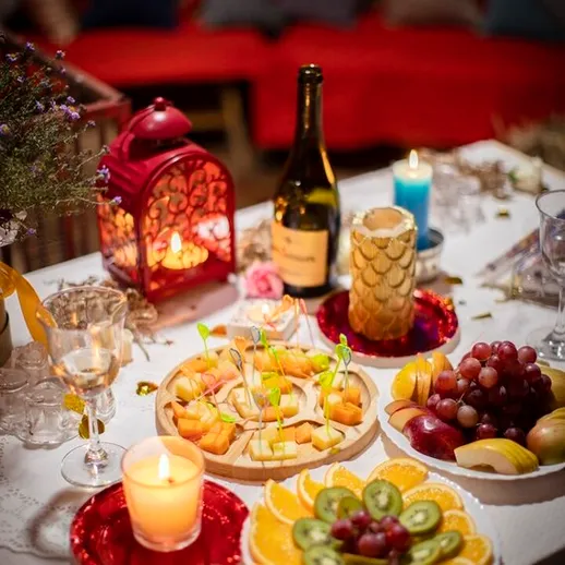 Праздничный стол с угощениями и атмосферными огнями на вечернем мероприятии