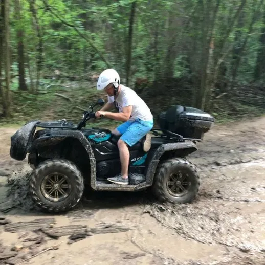 Объезд по грязи на квадроцикле в лесу в ясный день