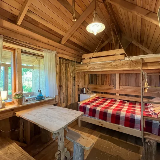 Уютная деревянная спальня в загородном доме с большим окном и ярким пледом на кровати