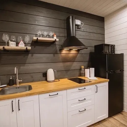 Минималистичная кухня в деревянном доме с черными стенами и стильной мебелью