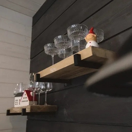 Стеклянные бокалы и декор в уютном интерьере на деревянной стене