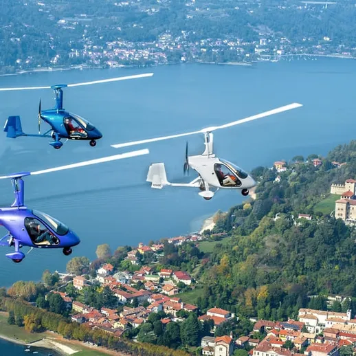 Трёхмоторные автожиры в воздухе над живописным озером с историческим замком на берегу