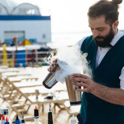 Бармен готовит коктейли на палубе теплохода в солнечный день