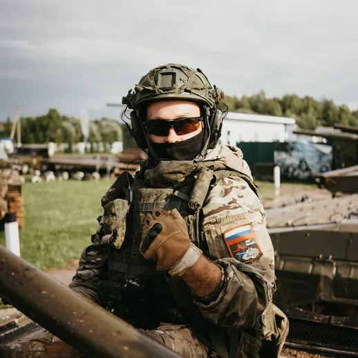 Солдат в военной форме с оружием на танке во время учений в России