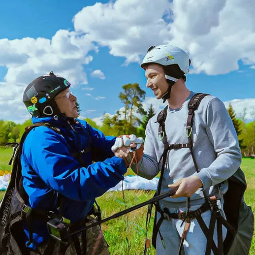 Параглайдеры в тренировочном центре на фоне голубого неба и облаков в летний день