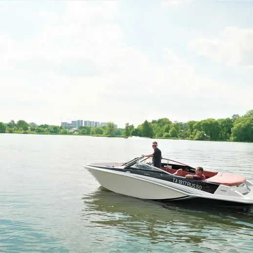 Люди наслаждаются поездкой наSpeedboat по спокойной воде реки в солнечный день