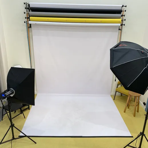 Студия для фотосессий с белым фоном и освещением, расположенная в помещении, подходящая для профессиональной съемки