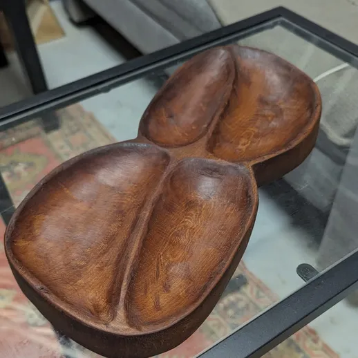 Деревянная ваза, выполненная в форме симметричного изделия, на стеклянном столе в уютной гостиной