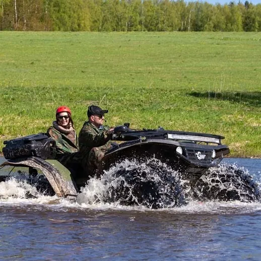 Квадроцикл преодолевает водное препятствие на природе в солнечный день возле леса