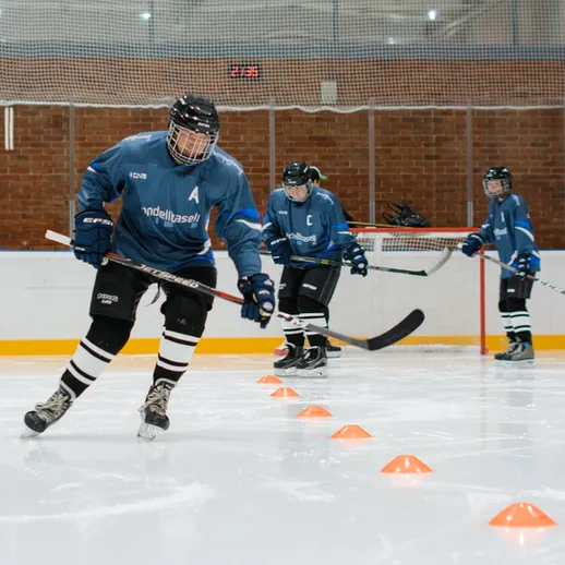 Тренировка юных хоккеистов на льду в спортивном комплексе в зимний период