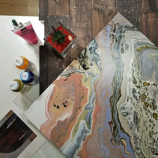 Креативный процесс: акриловая живопись на холсте и художественные материалы на столе в арт-пространстве