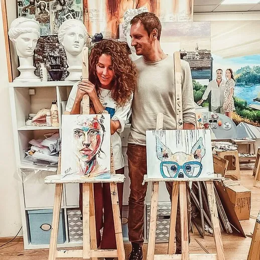 Пара художников в студии рисует картины, окруженные художественными принадлежностями и вдохновляющей атмосферой