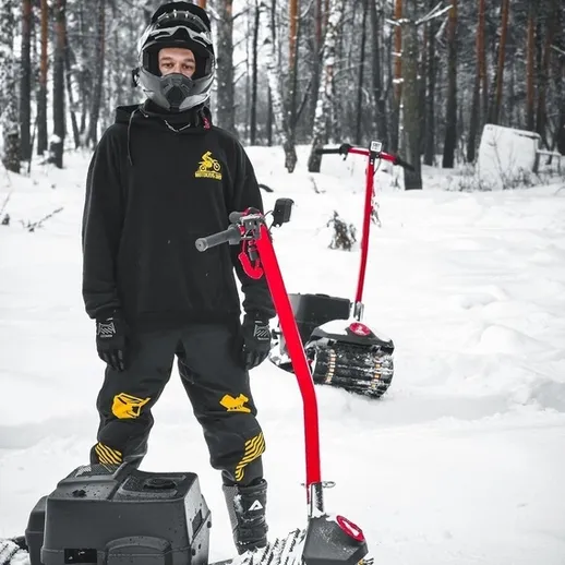 Зимние забавы на снегоходах в лесу: парень в защитной экипировке готов к катанию по снегу